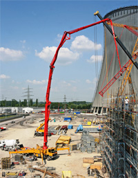 Long-reach boom pumps and bulk material conveyors at power plant construction site